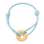 Light blue bracelet with a gold circular charm on a white background