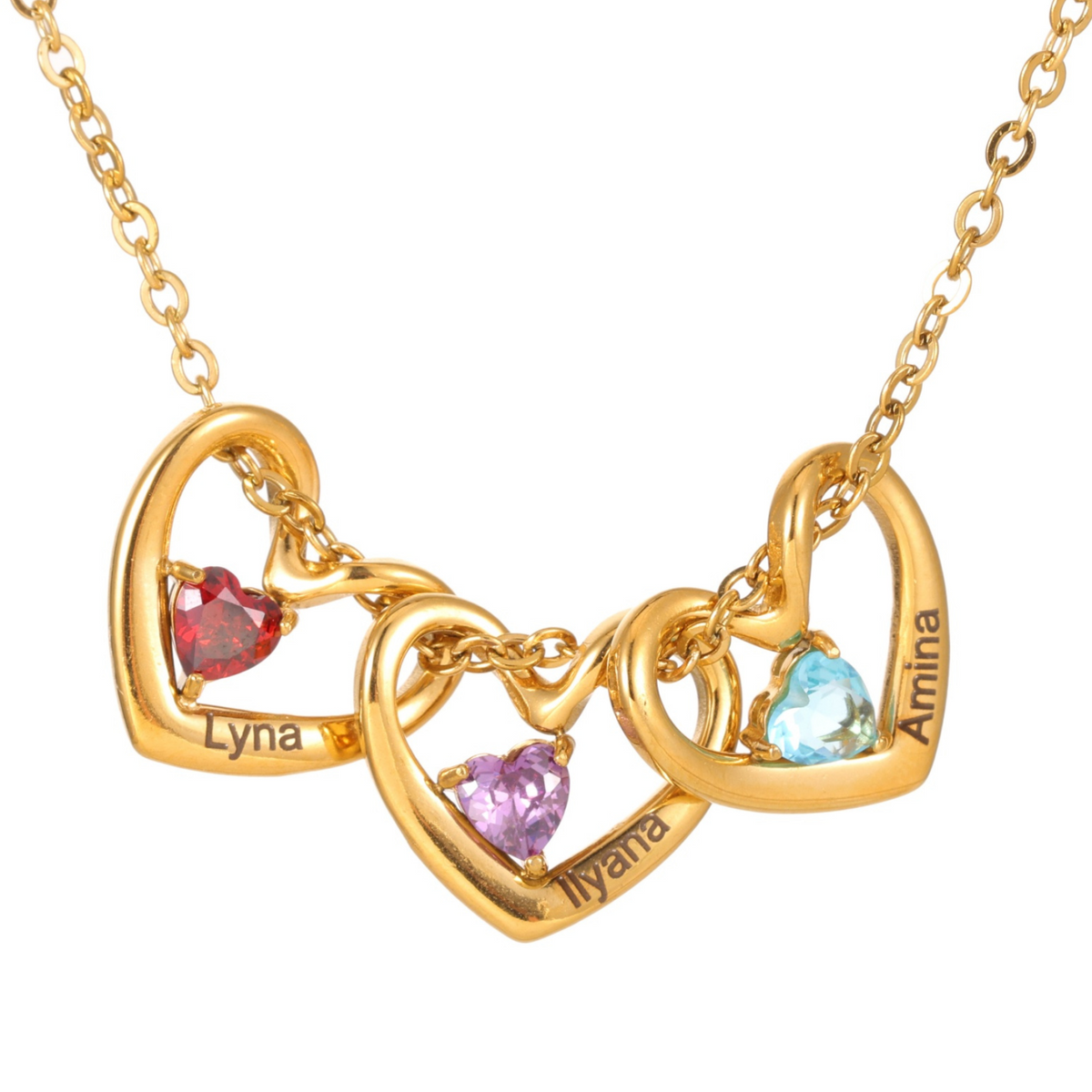 Gold necklace with interlocking heart pendants featuring names and colorful gemstones on a white background.