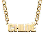 A gold-plated personalised name necklace with the name 'CHLOE' written in bold, standout font, attached to a thick chain.